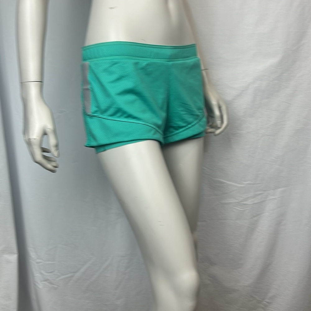 ROXY Women's 2 in 1 Green Athletic Shorts with reflective strips on each side.